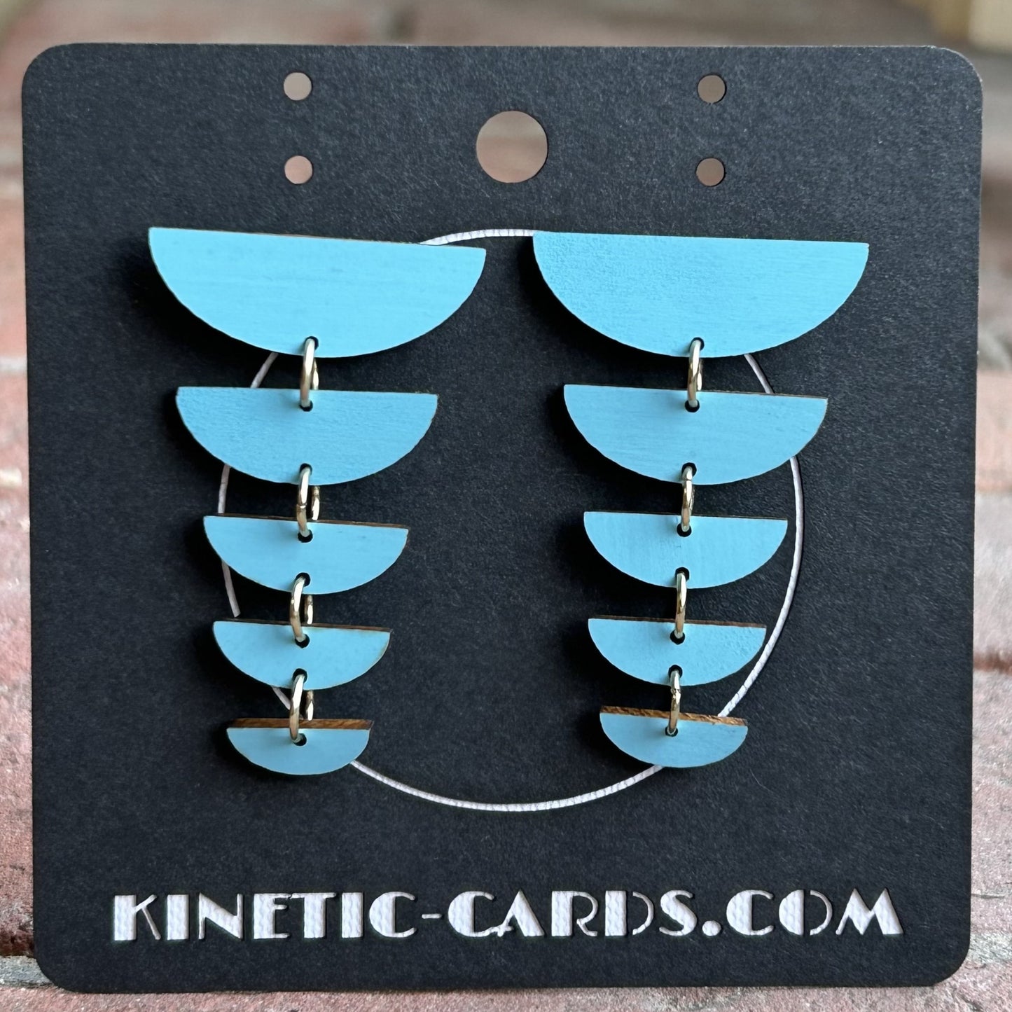 Blue earrings on a black card with 'Kinetic-Cards.com' text