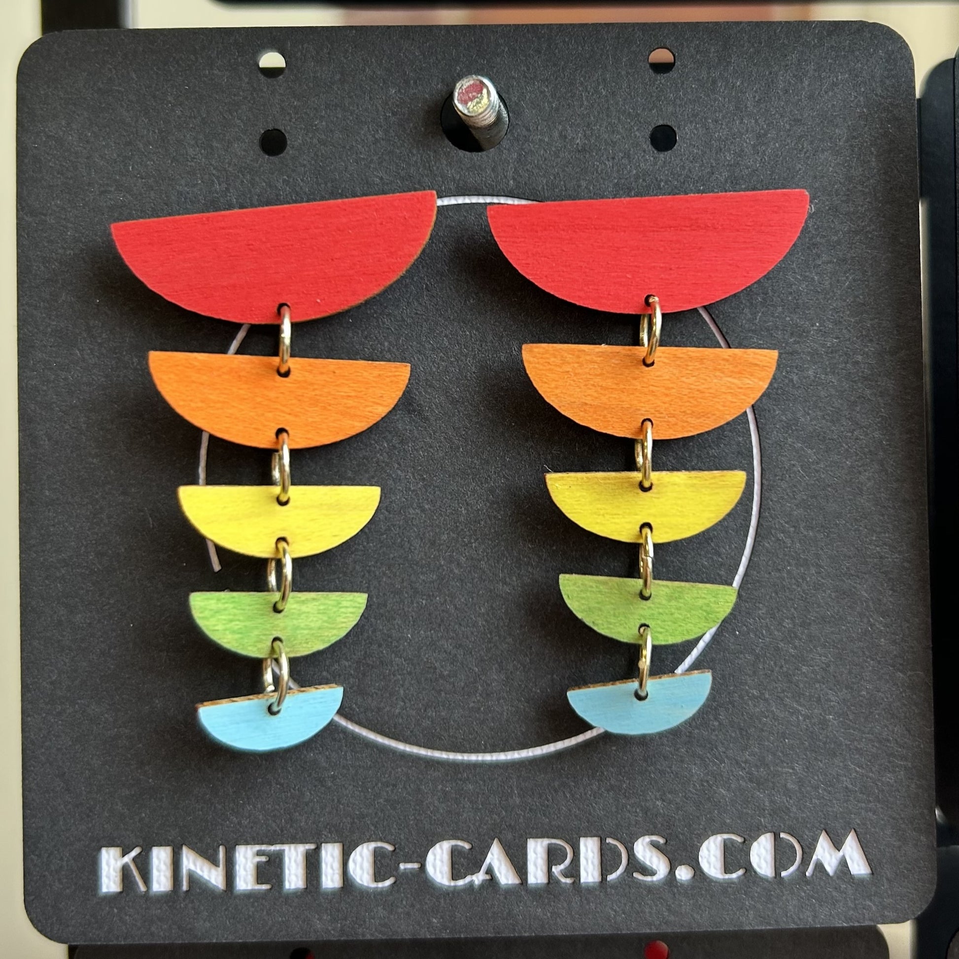 Colorful earrings on a Kinetic-Cards.com branded card