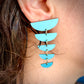 Close-up of a person wearing a blue geometric earring.