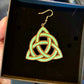 Celtic knot earrings in a black box held by a person.