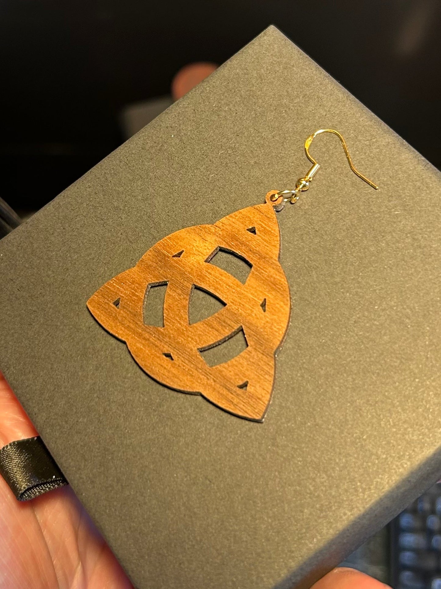Wooden earrings with gold hooks on a gray surface