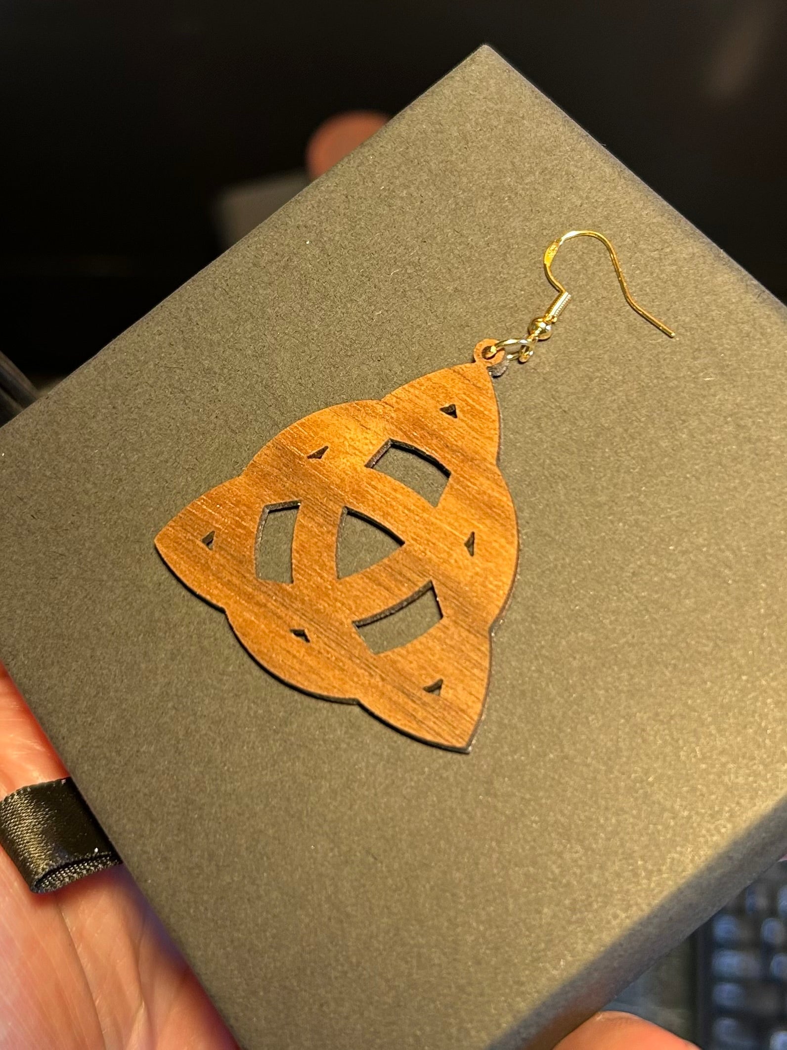 Wooden earrings with gold hooks on a gray surface